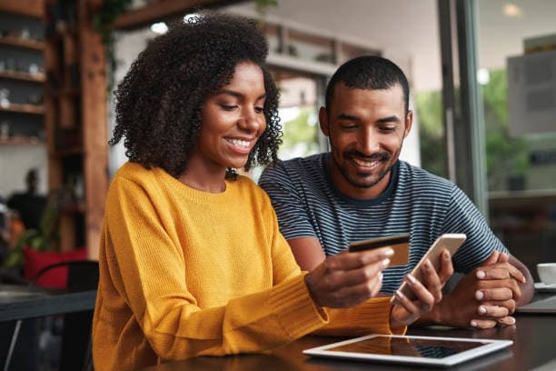 Smiling couple reviewing banking on a phone